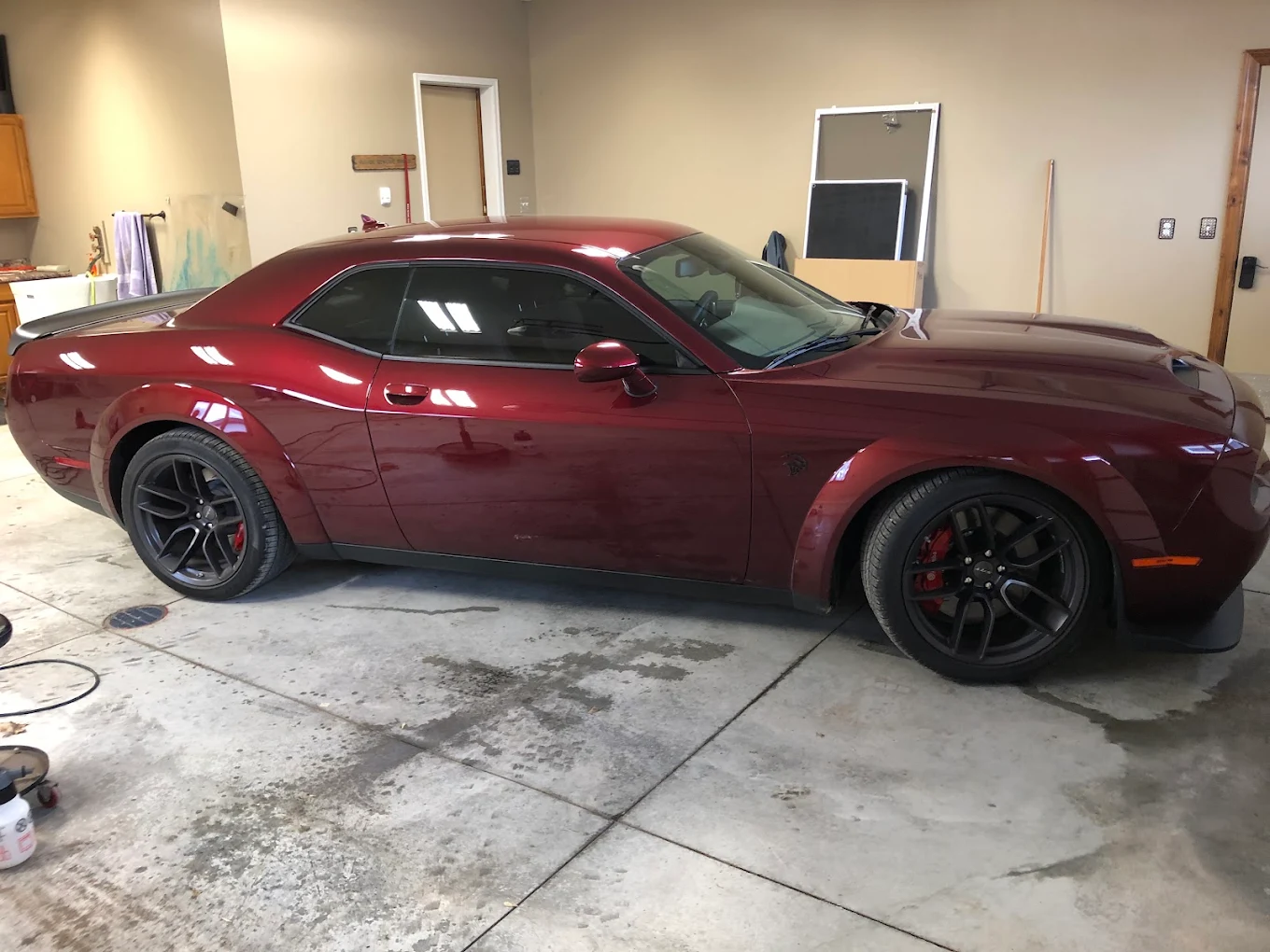 Deep red Dodge Challenger with freshly tinted windows parked in the Executive Film shop